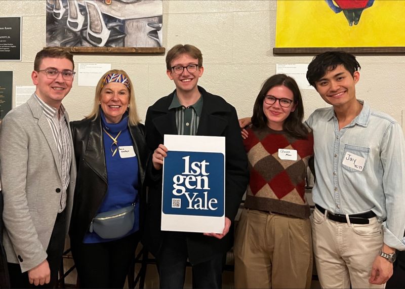 Five alums stand with a sign saying 1stGenYale